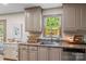 Charming kitchen sink area with neutral cabinets, a window view, and modern fixtures for functionality and style at 1338 Pell Dr, Lincolnton, NC 28092
