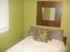 Cozy bedroom featuring a comfortable bed, window with blinds, and stylish mirror on green painted walls at 146 Barclay Ln, Mooresville, NC 28115