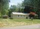 Charming single-story home with a metal roof, manicured lawn, and lush landscaping at 146 Barclay Ln, Mooresville, NC 28115