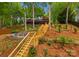 Spacious backyard with mature trees, firepit, and steps to the house at 146 Paradise Peninsula Rd, Mooresville, NC 28117