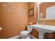 Stylish half bath with a pedestal sink, decorative mirror, and warm lighting at 146 Paradise Peninsula Rd, Mooresville, NC 28117