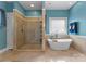 Bright bathroom featuring a large soaking tub, walk-in shower with glass door, and window at 146 Paradise Peninsula Rd, Mooresville, NC 28117