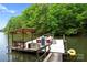 Boat dock with a covered area and a boat in the water at 146 Paradise Peninsula Rd, Mooresville, NC 28117