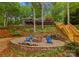 Landscaped backyard with a stone fire pit and Adirondack chairs at 146 Paradise Peninsula Rd, Mooresville, NC 28117
