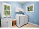 Practical laundry room with washer, dryer, utility sink, and ample storage cabinets for convenience at 146 Paradise Peninsula Rd, Mooresville, NC 28117