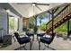 Covered patio with a table, chairs, and steps leading to the lawn at 146 Paradise Peninsula Rd, Mooresville, NC 28117