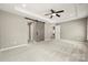 Neutral bedroom with a barn door leading to the bathroom and a tray ceiling with fan at 14625 Lyon Hill Ln, Huntersville, NC 28078