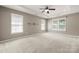 Spacious bedroom features neutral paint, tray ceilings, ceiling fan, and large windows at 14625 Lyon Hill Ln, Huntersville, NC 28078
