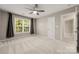 Large bedroom features a ceiling fan, a window with curtains, and a doorway to another room at 14625 Lyon Hill Ln, Huntersville, NC 28078