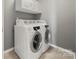 Modern laundry room with white cabinets and front loading washer and dryer at 14625 Lyon Hill Ln, Huntersville, NC 28078