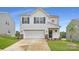 Charming two-story home with a two-car garage, classic white siding, and complementary landscaping at 151 Astor St, Troutman, NC 28166