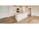 Modern kitchen with white cabinets, stainless steel appliances, large center island, and hardwood floors at 151 Astor St, Troutman, NC 28166