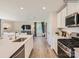 Modern kitchen featuring stainless steel appliances, a large island, and an open view into the living area at 151 Astor St, Troutman, NC 28166