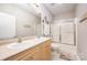 Well-lit bathroom with double sinks, spacious vanity, and glass-enclosed shower at 15318 Coventry Court Ln, Charlotte, NC 28277