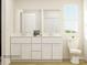 Modern bathroom featuring a double vanity, large mirror, white cabinets, and neutral walls at 155 Astor St, Troutman, NC 28166