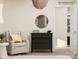 Comfortable bedroom showcasing a cozy glider, dark wood dresser with round mirror, and neutral decor at 155 Astor St, Troutman, NC 28166