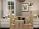 A charming Bedroom with a wooden crib, playful bear artwork, and soft lighting for a warm and inviting atmosphere at 155 Astor St, Troutman, NC 28166