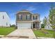 Charming two-story home featuring a two-car garage, well-manicured lawn, and inviting entrance at 155 Astor St, Troutman, NC 28166