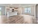 Open kitchen and living area with hardwood floors, white cabinets, and stainless steel appliances at 155 Astor St, Troutman, NC 28166