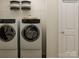 Modern laundry room with front-load washer and dryer and white storage at 155 Astor St, Troutman, NC 28166