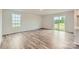 Open-concept living room featuring sliding glass door, large window, and beautiful hardwood flooring at 155 Astor St, Troutman, NC 28166