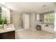 Bright bathroom with a glass-enclosed shower, soaking tub, and granite countertops at 15807 Foreleigh Rd, Huntersville, NC 28078