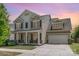 Inviting two-story home with a charming front porch, well-manicured lawn, and a two-car garage at 15807 Foreleigh Rd, Huntersville, NC 28078