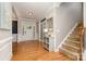 Bright foyer with hardwood floors, staircase, and wainscoting offering a welcoming entrance to the home at 15807 Foreleigh Rd, Huntersville, NC 28078