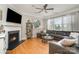 Cozy living room with a fireplace, hardwood floors, and plenty of natural light from large windows at 15807 Foreleigh Rd, Huntersville, NC 28078