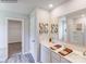 Bright bathroom with double sinks, white cabinets, large mirrors, and view into the walk-in closet at 1611 Spring Lot Dr, Edgemoor, SC 29712