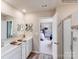 Bright bathroom has double sinks, white cabinets, large mirrors, and walk-in shower at 1611 Spring Lot Dr, Edgemoor, SC 29712