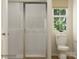 Bathroom featuring a modern toilet, shower with glass door, and a bright window at 1621 Spring Lot Dr, Edgemoor, SC 29712