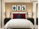 Modern bedroom with a white bed frame, minimalist artwork, and matching nightstands with lamps at 1621 Spring Lot Dr, Edgemoor, SC 29712