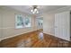 Well-lit bedroom with hardwood floors, a mirrored closet, and two windows at 1723 Baskins Hill Rd, Heath Springs, SC 29058