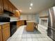 Spacious kitchen features tile floors, wood cabinets, black appliances, and center island with granite counter at 1723 Baskins Hill Rd, Heath Springs, SC 29058