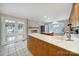 Bright kitchen with white brick fireplace, stainless refrigerator, island, and french doors to the side yard at 1723 Baskins Hill Rd, Heath Springs, SC 29058