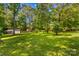 Backyard featuring lush greenery, mature trees, and a storage shed at 1760 Jacobs Way, Sherrills Ford, NC 28673