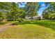 Spacious backyard with lush green grass, mature trees, and white house at 1760 Jacobs Way, Sherrills Ford, NC 28673