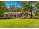 Traditional brick home featuring a well-manicured lawn and a patriotic flagpole at 1760 Jacobs Way, Sherrills Ford, NC 28673