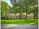 Charming single-story brick home with a lush green lawn, mature trees, and a flag pole at 1760 Jacobs Way, Sherrills Ford, NC 28673