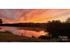 Picturesque view of the lake at sunset with a dock, reflected light, and colorful skies at 1780 Sierra Rd, York, SC 29745