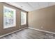 Well-lit bedroom with two windows, neutral walls, and wood-look flooring at 1806 Red Bird Cir, Concord, NC 28025