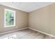 Bright bedroom features a window, neutral paint and wood-look flooring at 1806 Red Bird Cir, Concord, NC 28025