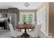 Virtually staged dining area next to the kitchen with gray cabinets, stainless steel refrigerator, and French doors at 1806 Red Bird Cir, Concord, NC 28025