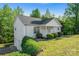 Inviting home with white siding, lush landscaping, and a charming front porch surrounded by mature trees at 1806 Red Bird Cir, Concord, NC 28025