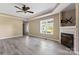 Bright living room with fireplace, hardwood flooring and large window offering views of the neighborhood at 1806 Red Bird Cir, Concord, NC 28025