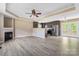 An open living room area featuring a fireplace, ceiling fan and hardwood floors leading into the kitchen at 1806 Red Bird Cir, Concord, NC 28025