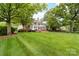 Expansive backyard featuring a lush green lawn, mature trees, a patio and a pergola, perfect for outdoor living at 18920 Peninsula Club Dr, Cornelius, NC 28031