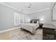 This cozy bedroom features a comfy queen bed, a window with plantation shutters, and light blue walls at 18920 Peninsula Club Dr, Cornelius, NC 28031