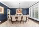 Formal dining room with dark blue walls, hardwood floors, a chandelier, and a large window, perfect for entertaining at 18920 Peninsula Club Dr, Cornelius, NC 28031